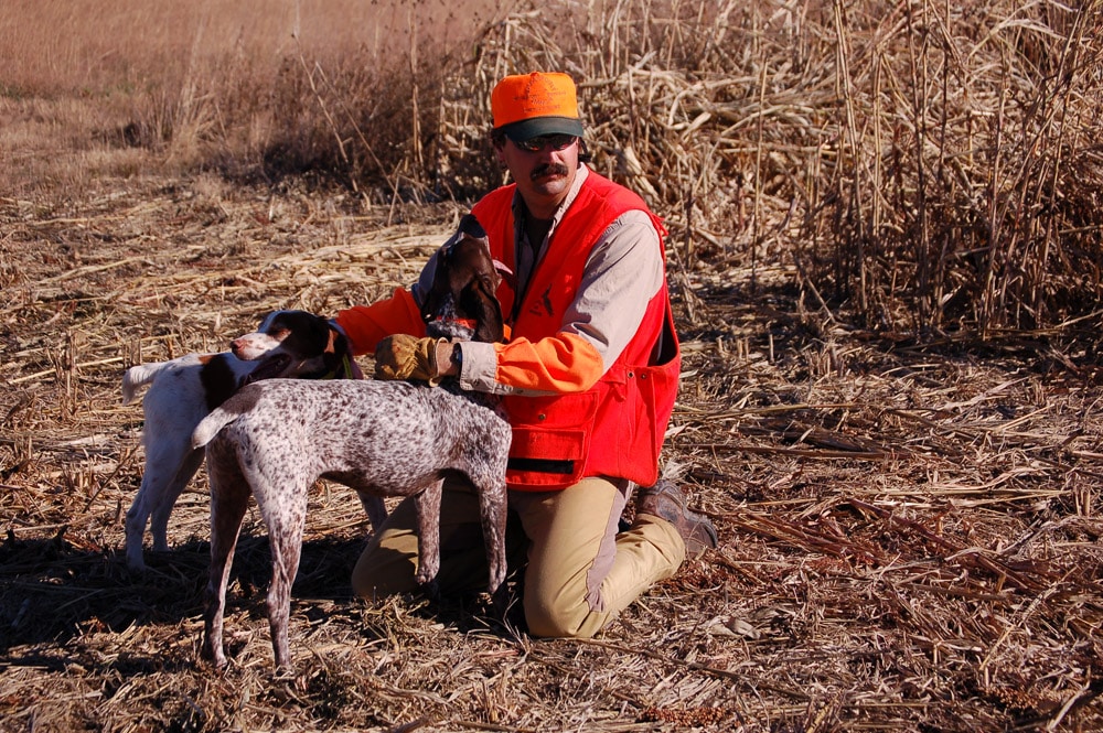 Hunter holding hunting dog in arms